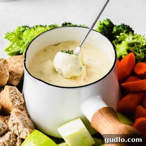 A close-up shot of rich, golden cheese fondue ready for dipping.