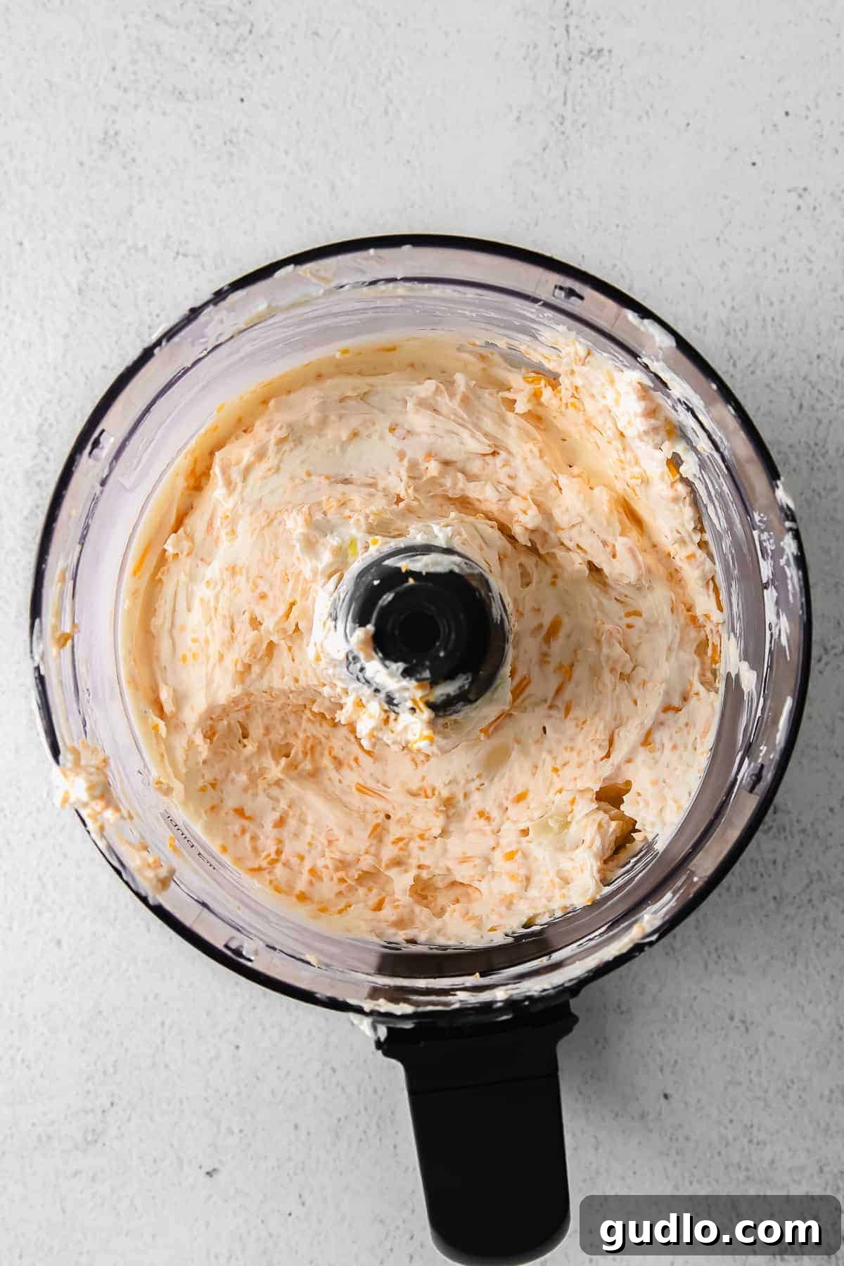 Cream cheese mixture for cheese ball bites in a food processor, ready to be blended