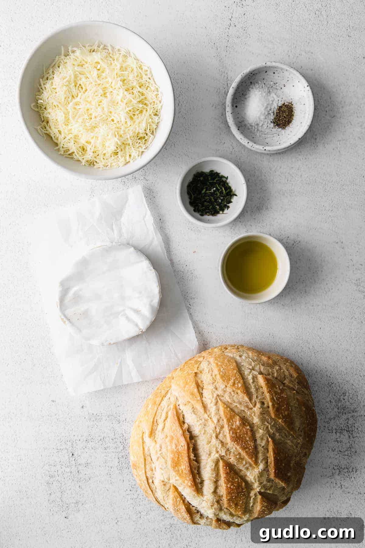 Sourdough baked brie is a fun twist on classic baked brie. Bake the brie inside a fresh loaf of sourdough and use the sides to scoop the cheesy deliciousness. Ingredients on countertop