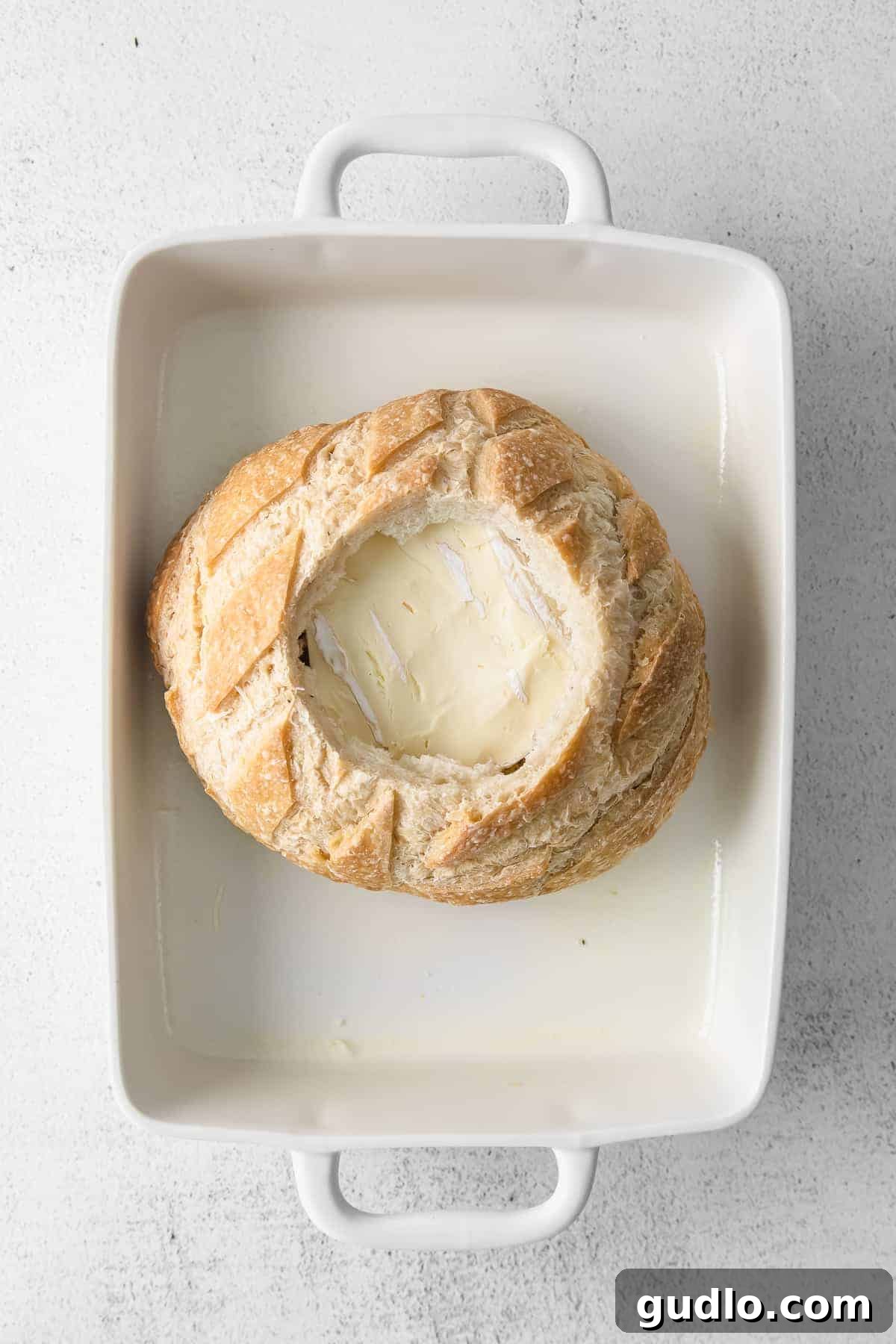 A simple baked brie in bread recipe made with a fresh sourdough loaf. Take your baked brie appetizer up a notch with this pull-apart idea. Baked brie in sourdough bread