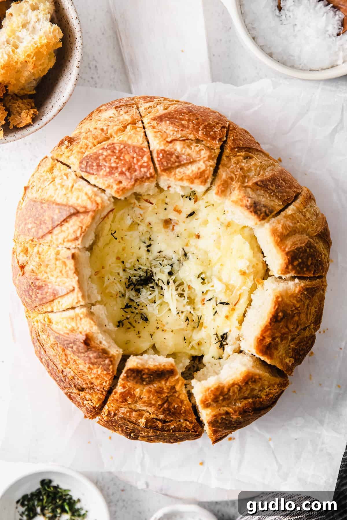 A simple baked brie in bread recipe made with a fresh sourdough loaf. Take your baked brie appetizer up a notch with this pull-apart idea. Sourdough baked brie
