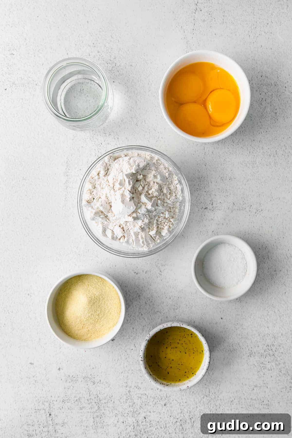 Various fresh ingredients for homemade cheese ravioli laid out on a table.
