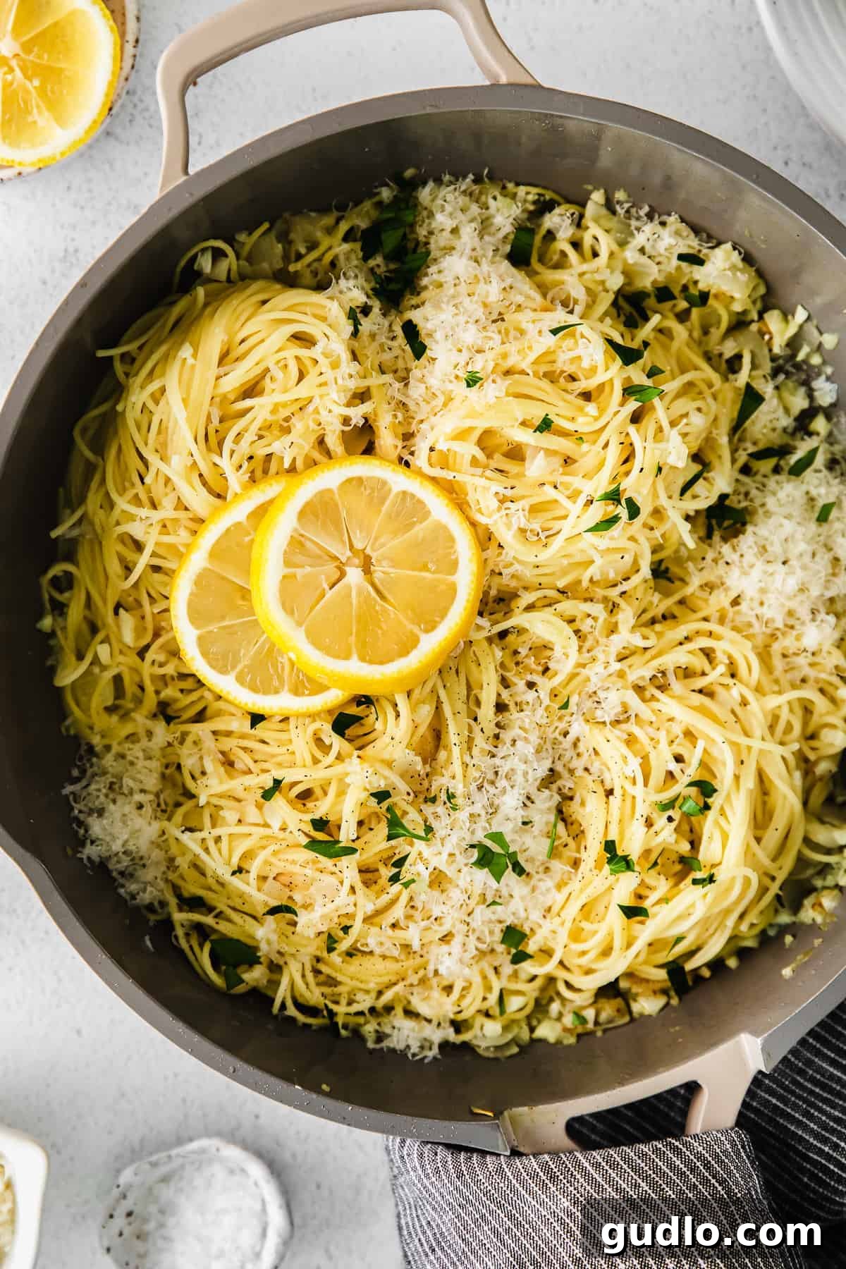 A beautifully plated dish of lemon garlic pasta, garnished with fresh parsley and lemon slices.