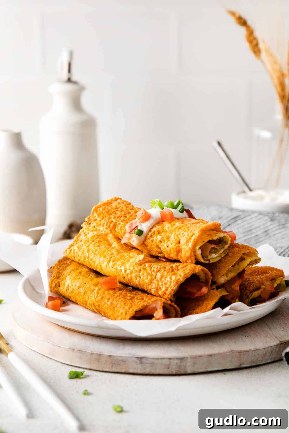 Perfectly Cooked Crispy Breakfast Taquitos A stack of golden brown, crispy breakfast taquitos on a white plate, showcasing their inviting texture and readiness to be served.