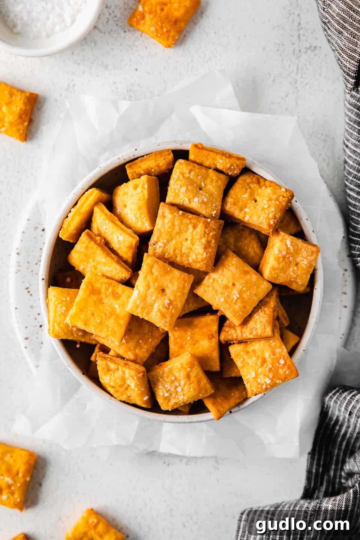 You only need 6 basic ingredients to make these perfectly crunchy and salty Homemade Cheez Its! Homemade Cheez-Its in a serving bowl, showcasing their golden crispness.
