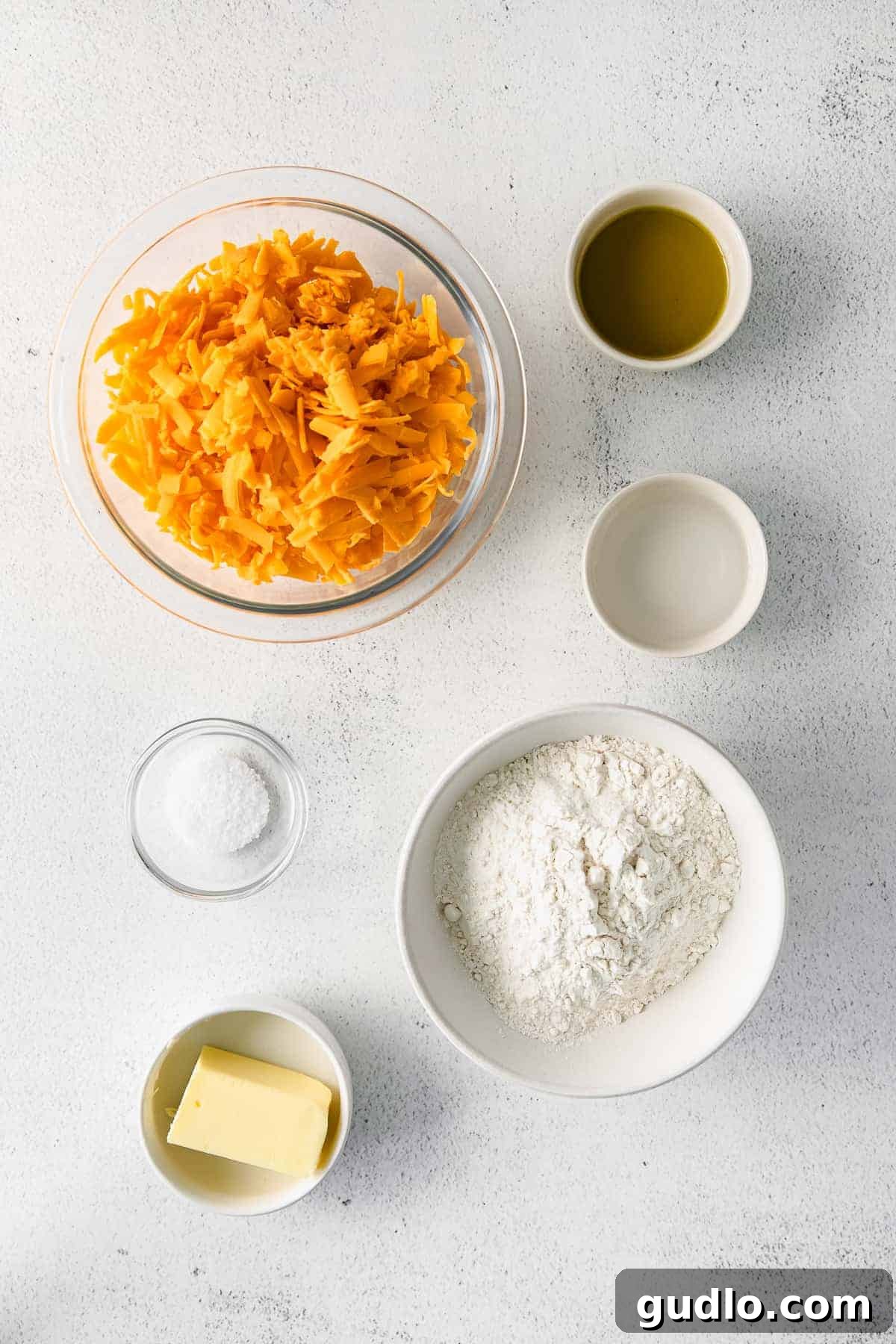 You only need 6 basic ingredients to make these perfectly crunchy and salty Homemade Cheez Its! Arranged ingredients for homemade Cheez-Its on a kitchen counter, ready for preparation.