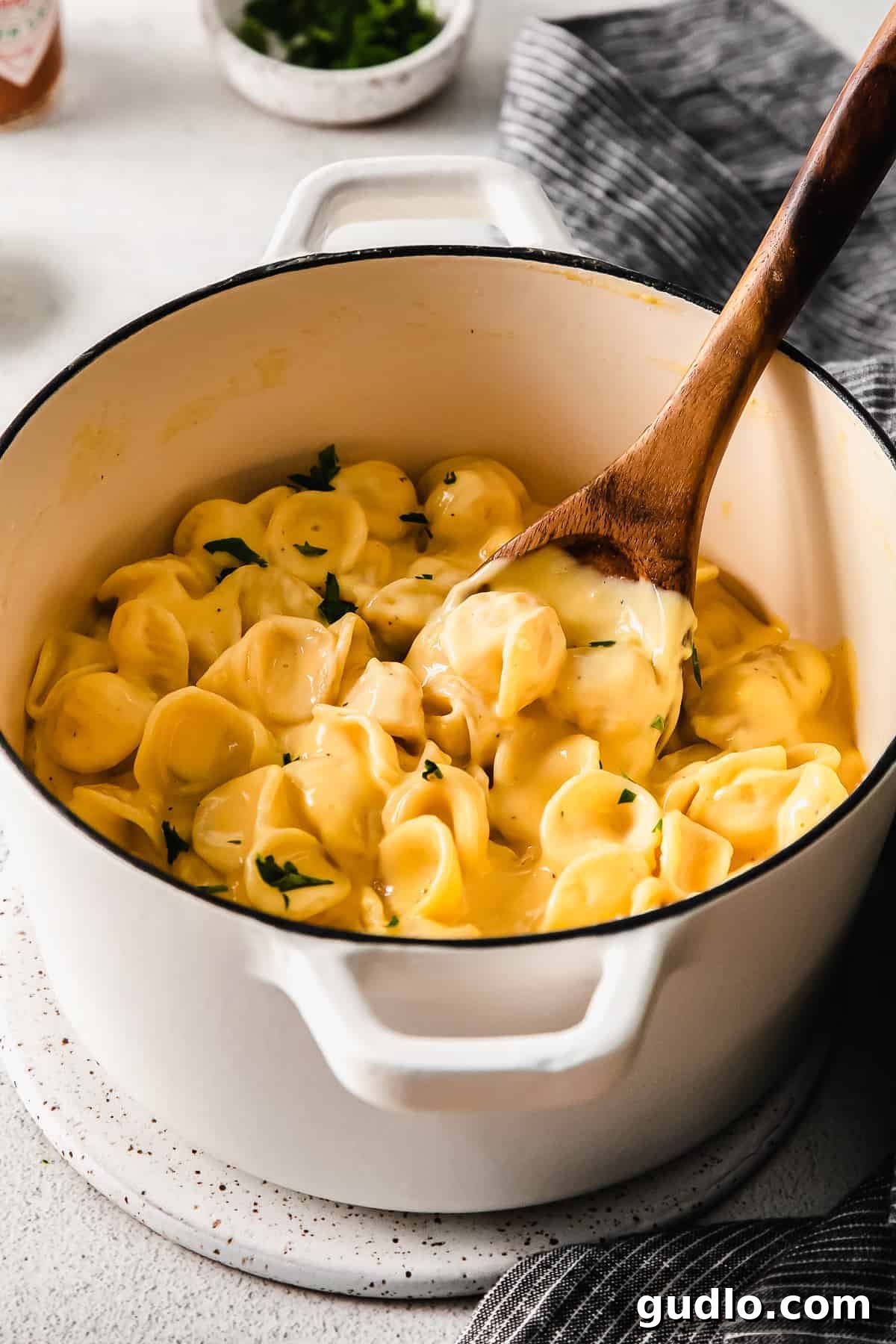 Our Ultimate Velveeta Cheese Sauce is oh so creamy and flavorful and made with easy ingredients. Pair with your favorite pasta, and enjoy! Velveeta mac and cheese in a stock pot with a wooden spoon, ready to be served