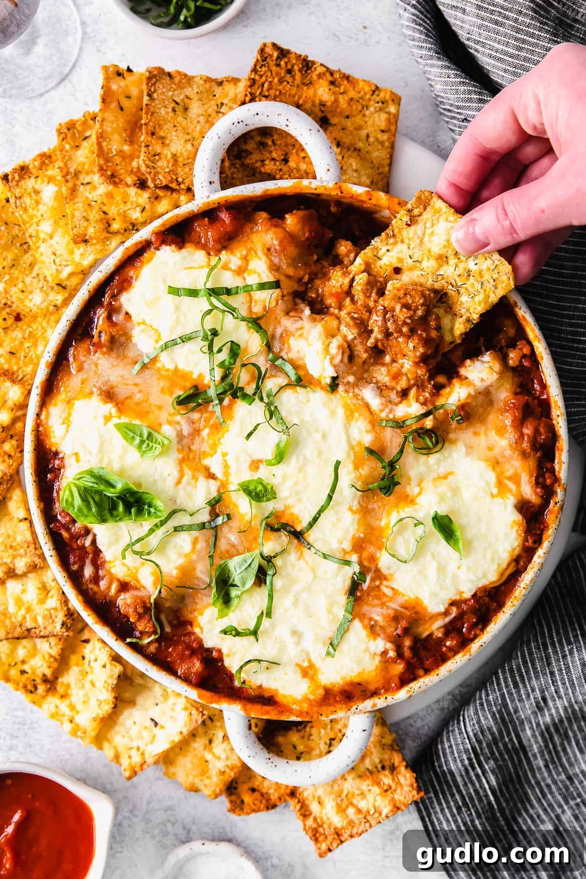 Skillet Lasagna Bake 6 Crispy air fryer pasta chip scooping up a generous amount of cheesy lasagna dip