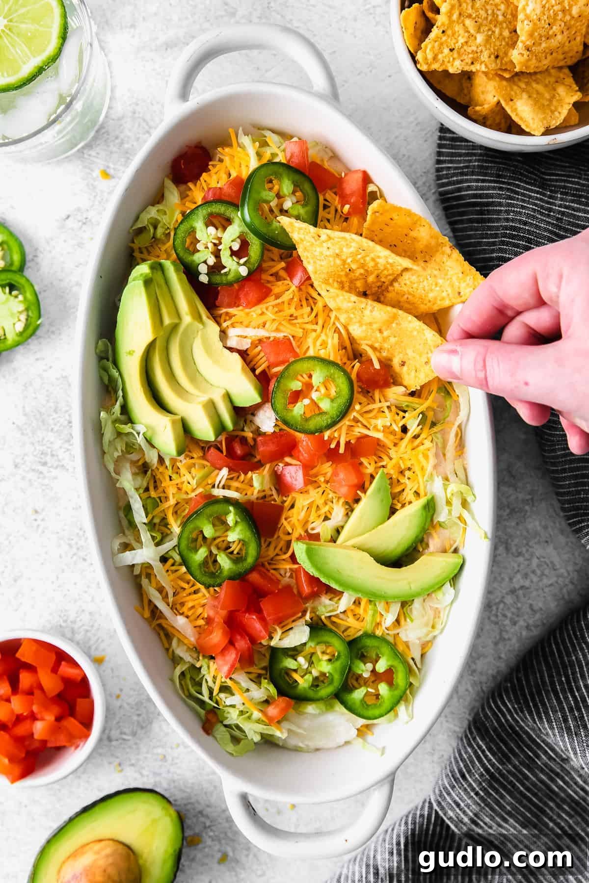 Taco dip topped with fresh avocado slices and vibrant jalapeños, ready for serving.