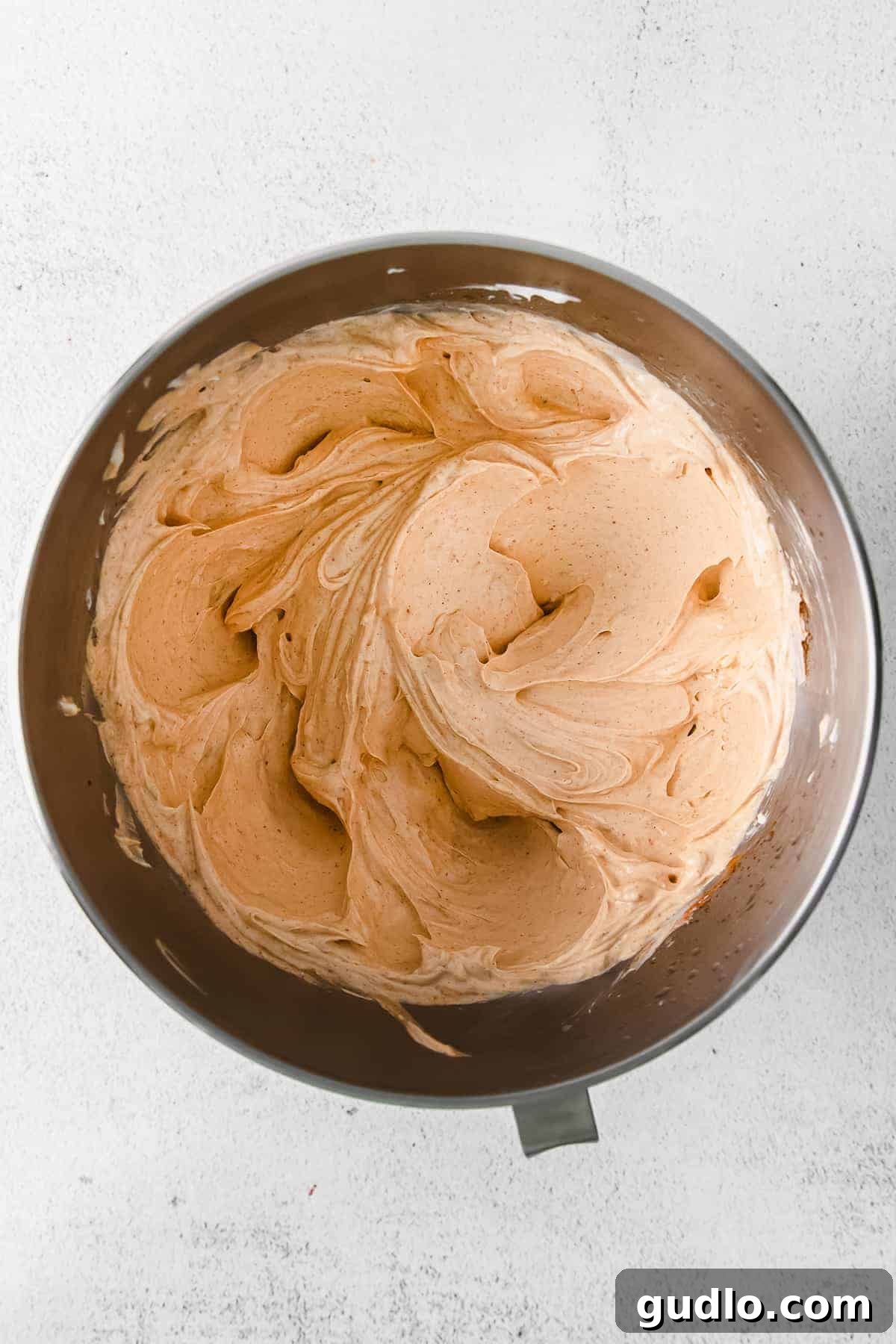 Close-up of the smooth, creamy cream cheese and Greek yogurt mixture for taco dip in a mixing bowl.
