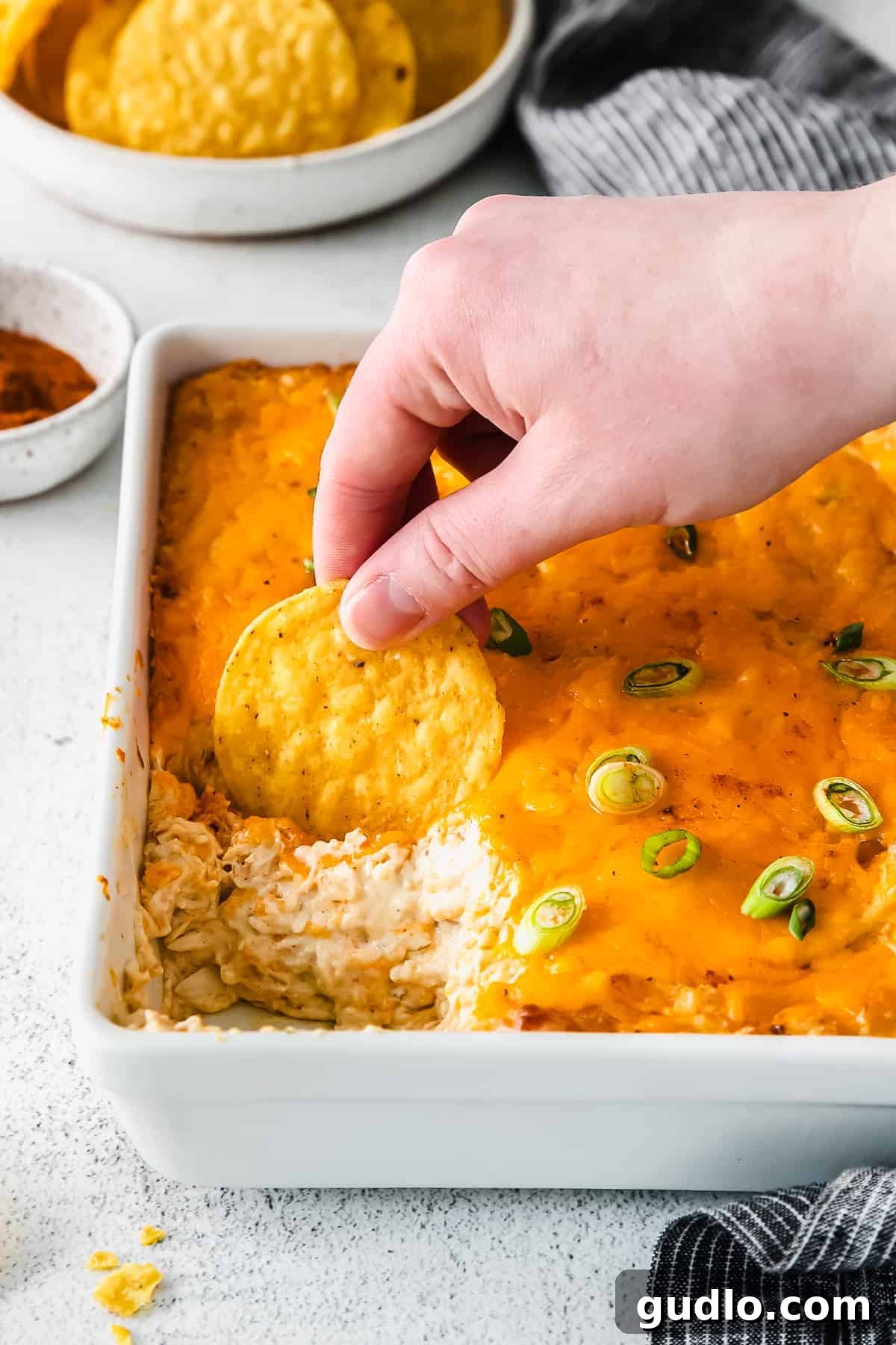 Ultimate Cheesy Crab Dip 8 A serving spoon lifting a portion of hot crab dip from a dish, highlighting its creamy and cheesy texture.