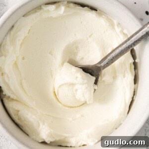 Whipped cream in a bowl with a spoon, light and fluffy.