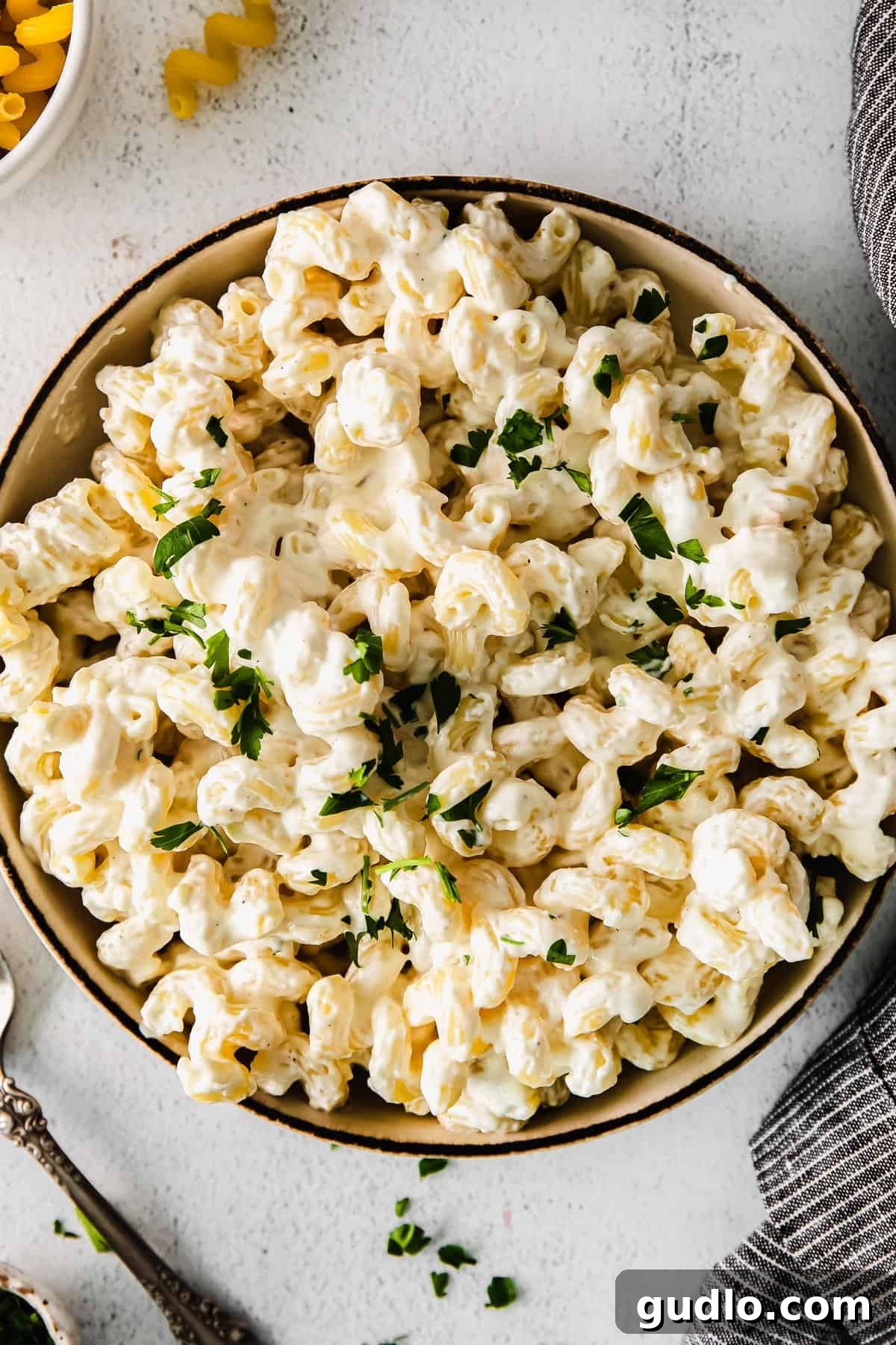 A bowl of creamy cream cheese pasta, garnished with fresh herbs.
