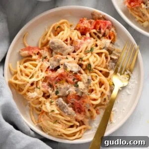 A baked plate of cream cheese pasta with tomatoes, golden and bubbling.
