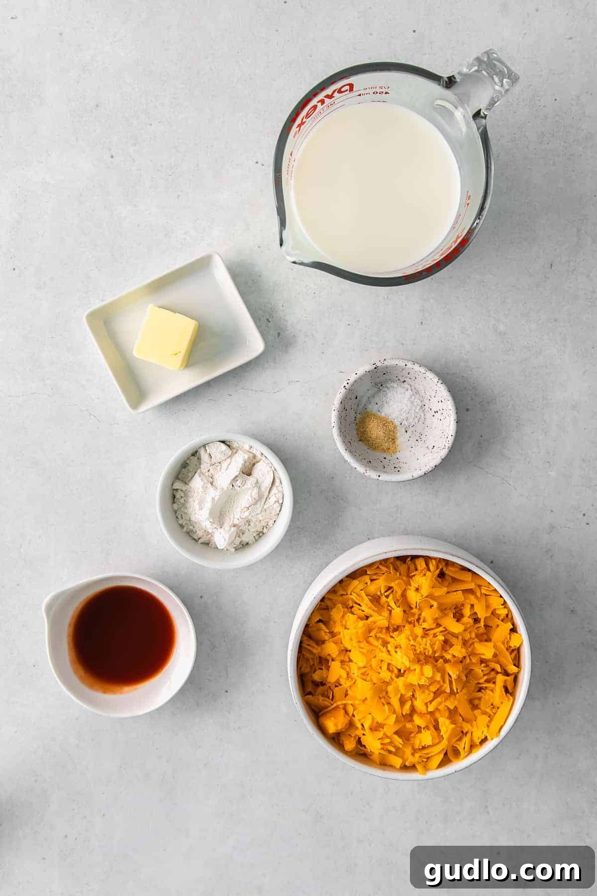 All the fresh ingredients for the broccoli cheese sauce laid out in small bowls.