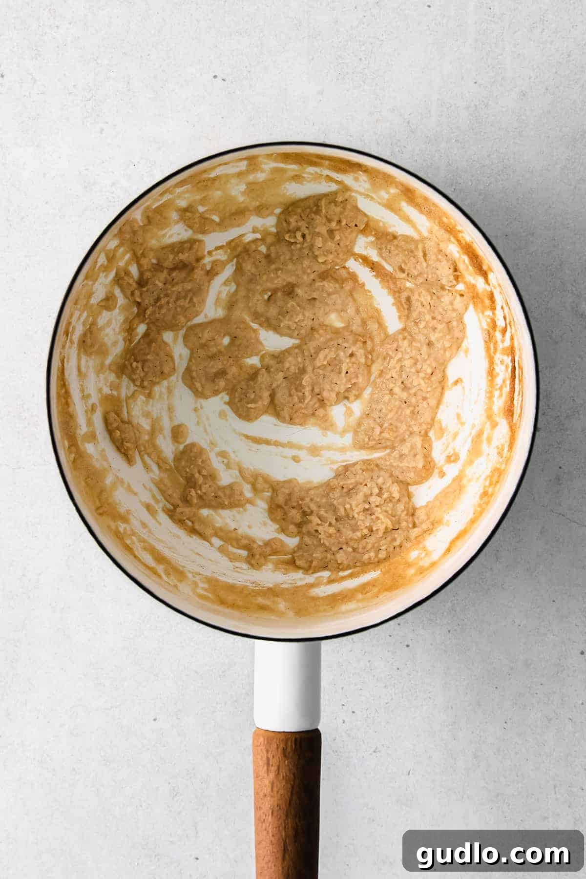 A smooth flour and butter paste (roux) simmering in a saucepan.