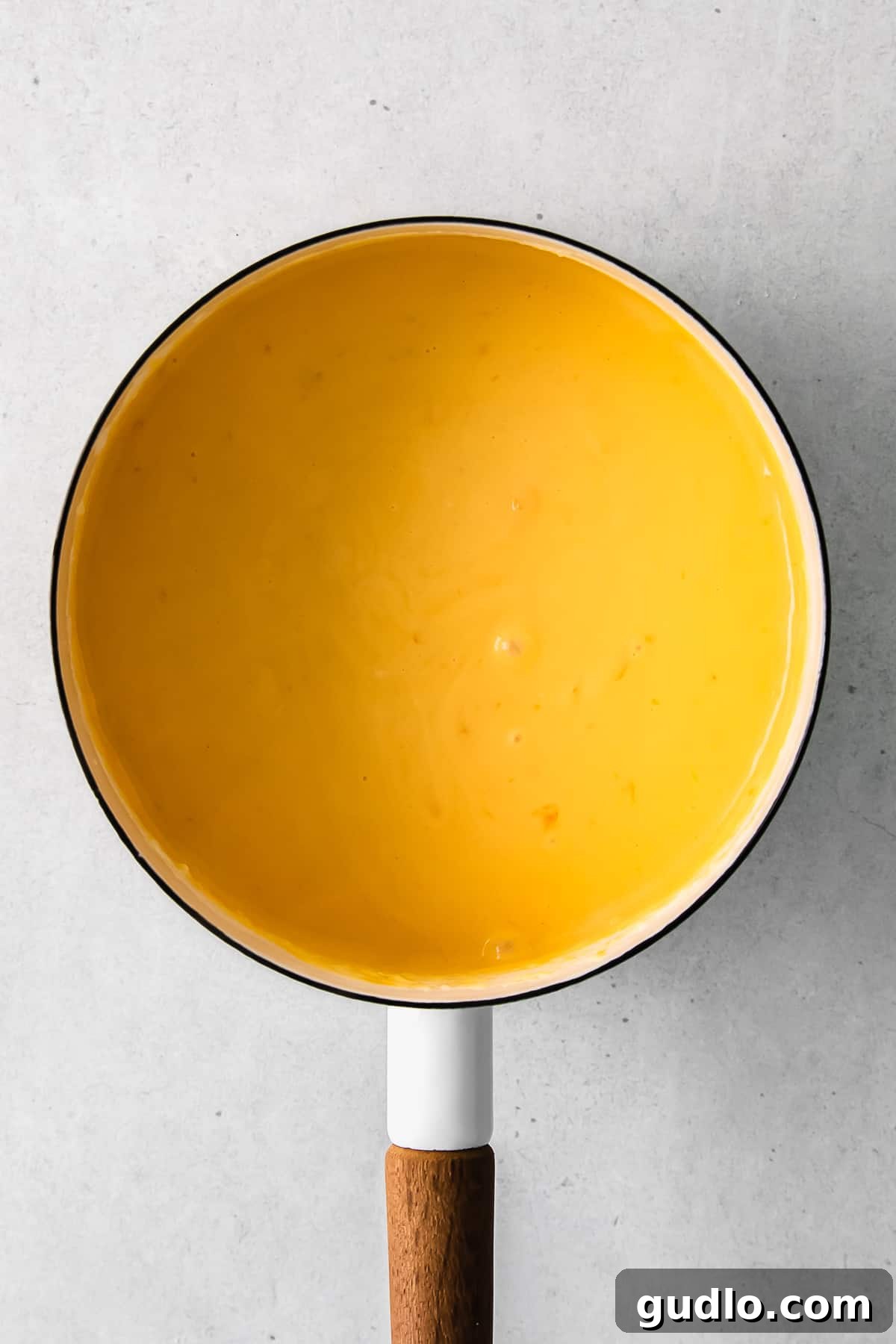 Delicious cheese sauce simmering gently in a pan, ready for serving.