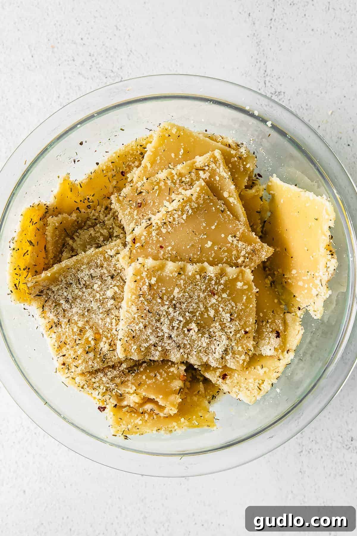 Cooked lasagna noodles tossed with olive oil and spices in a bowl