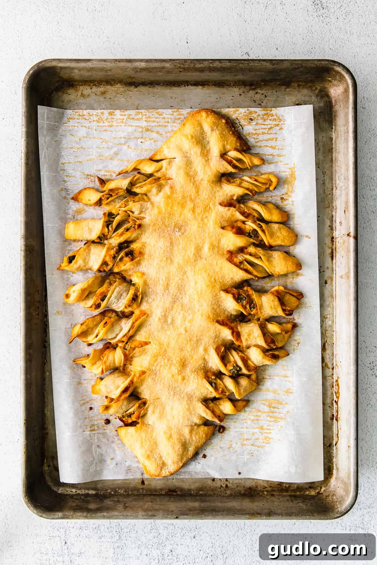 It's game day and we're making these jalapeño popper football-shaped stuffed cheesy breadsticks! This appetizer is a deliciously perfect dish to pass. football cheesy breadsticks on a baking sheet