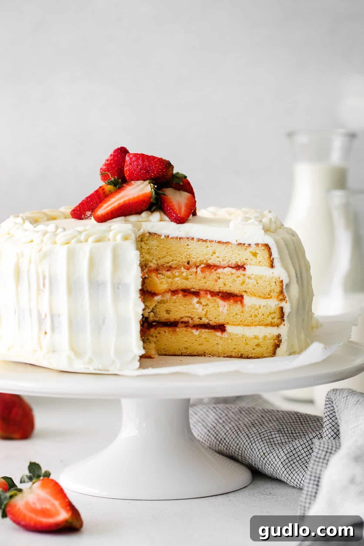 Dreamy Strawberry Ricotta Layer Cake 12 A slice of strawberry ricotta layer cake on a plate with a fork, ready to be enjoyed.