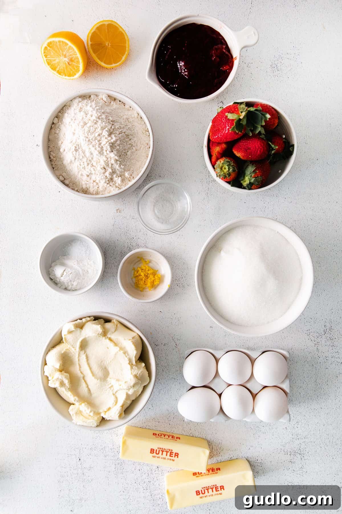 Dreamy Strawberry Ricotta Layer Cake 3 Essential ingredients for a strawberry ricotta layer cake: fresh strawberries, strawberry preserves, rich whole milk ricotta cheese, all-purpose flour, and other baking staples laid out on a kitchen counter.