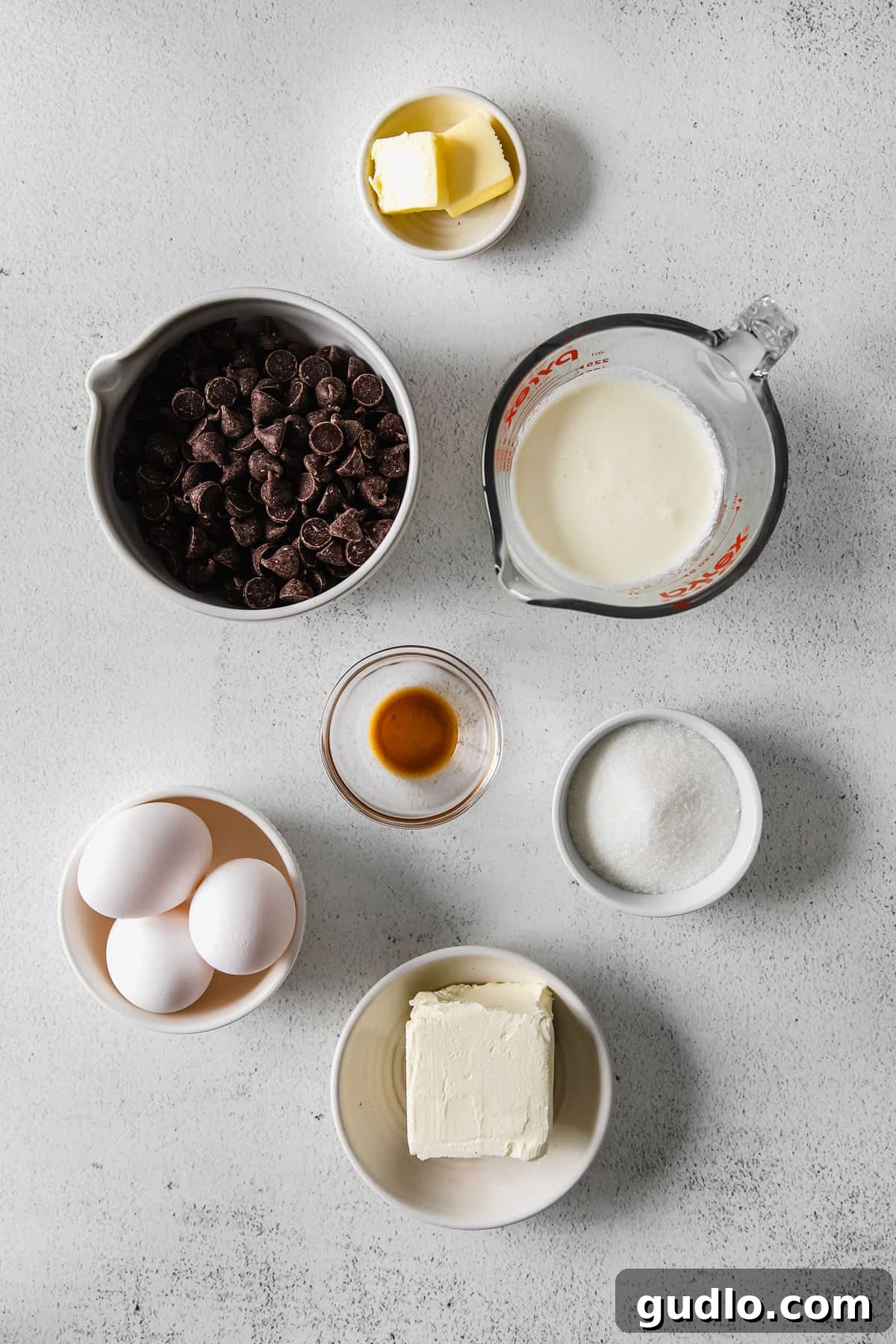 Various ingredients for the chocolate cream cheese tart, neatly arranged in small, separate bowls.