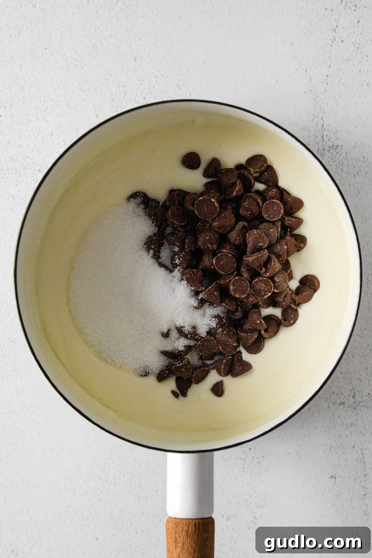 Cream cheese, chocolate chips, and sugar ready to be melted together in a bowl, illustrating the start of the tart filling.