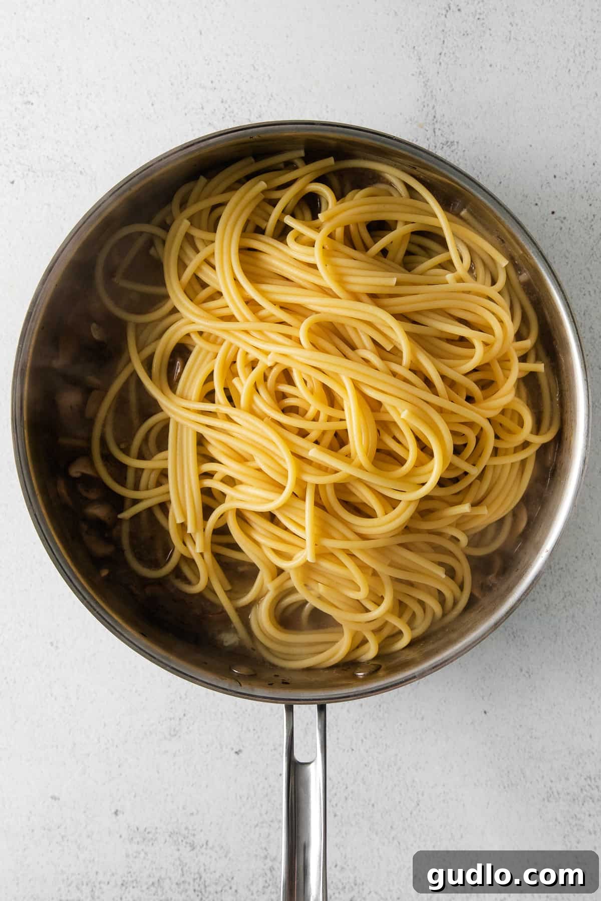 noodles in skillet, coated in savory sauce