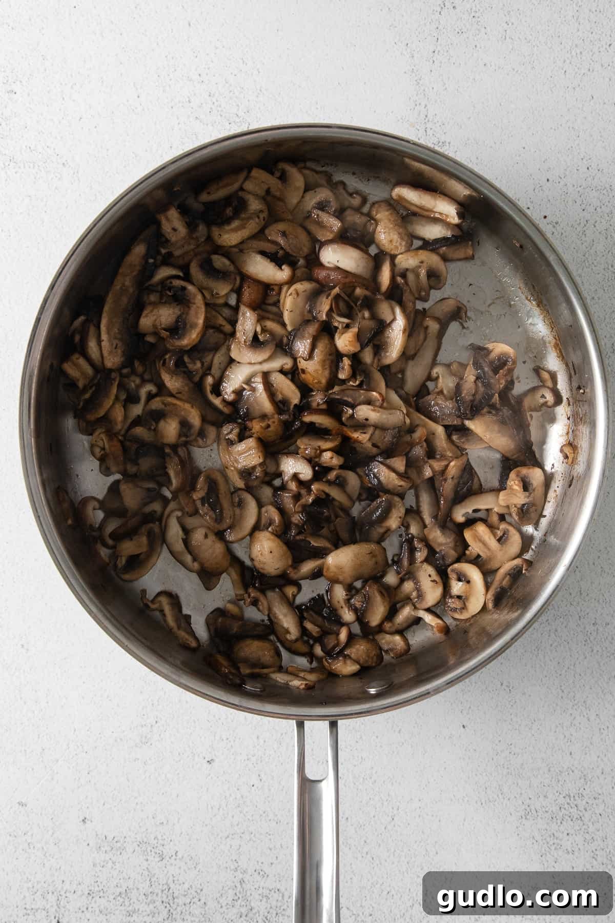 cooked mushrooms sizzling in a skillet