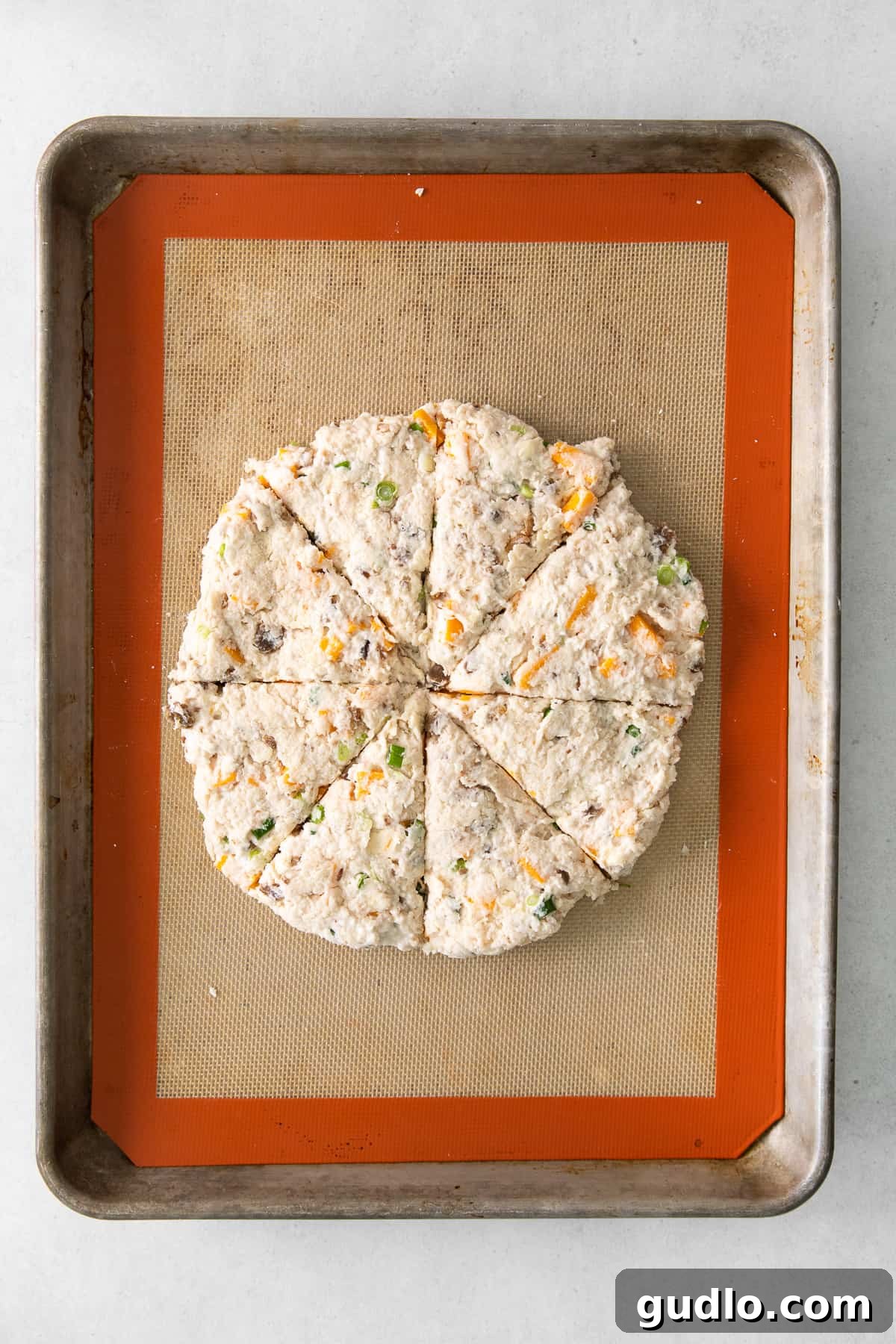 Prepared Bacon Cheddar Scone Dough The combined savory scone dough, rich with bacon and cheddar, ready for shaping on a lightly floured surface.