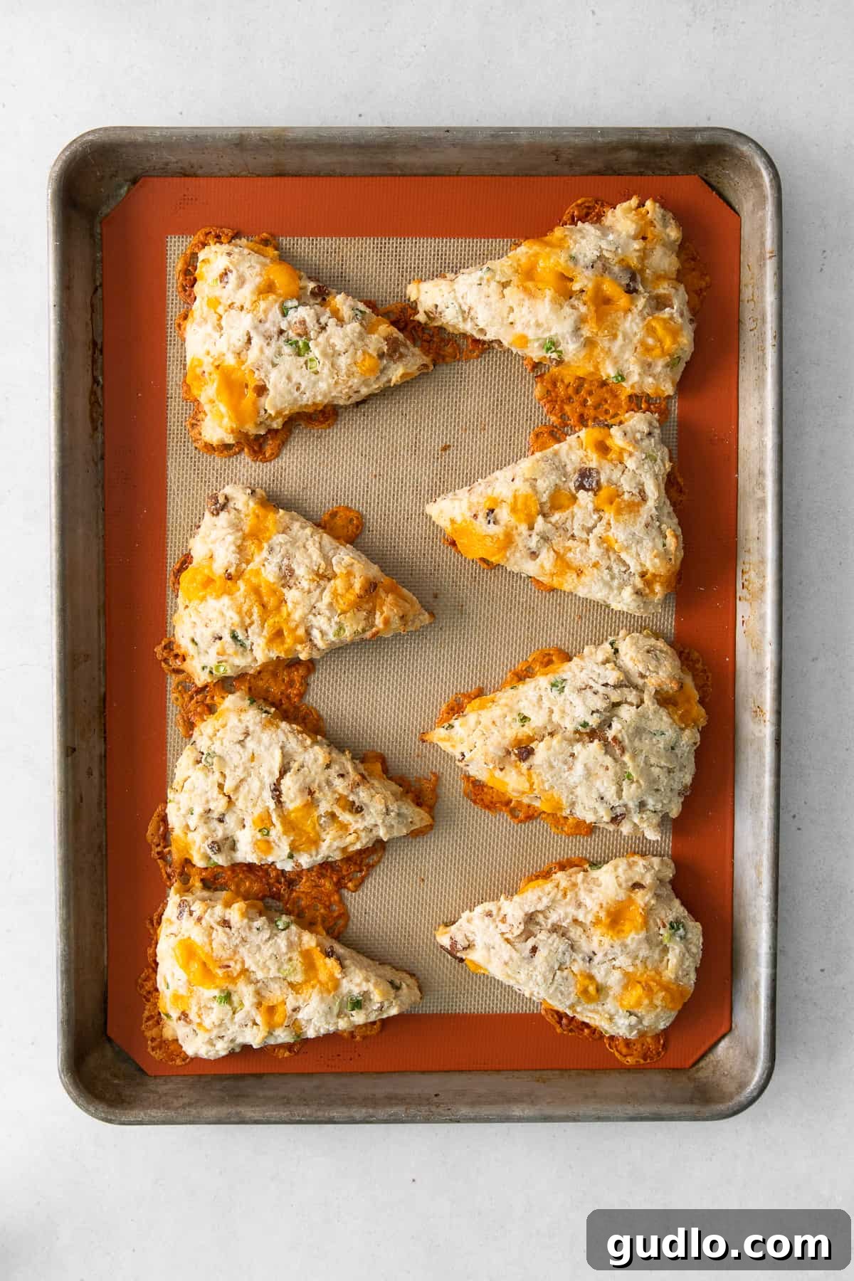 Baked Buttermilk Bacon Cheddar Scones Ready to Serve Freshly baked Bacon Cheddar Scones, golden and perfectly risen, cooling on a wire rack on a baking sheet, with visible melted cheese pockets.