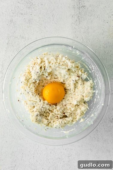 an egg in a glass bowl resting on a white background.