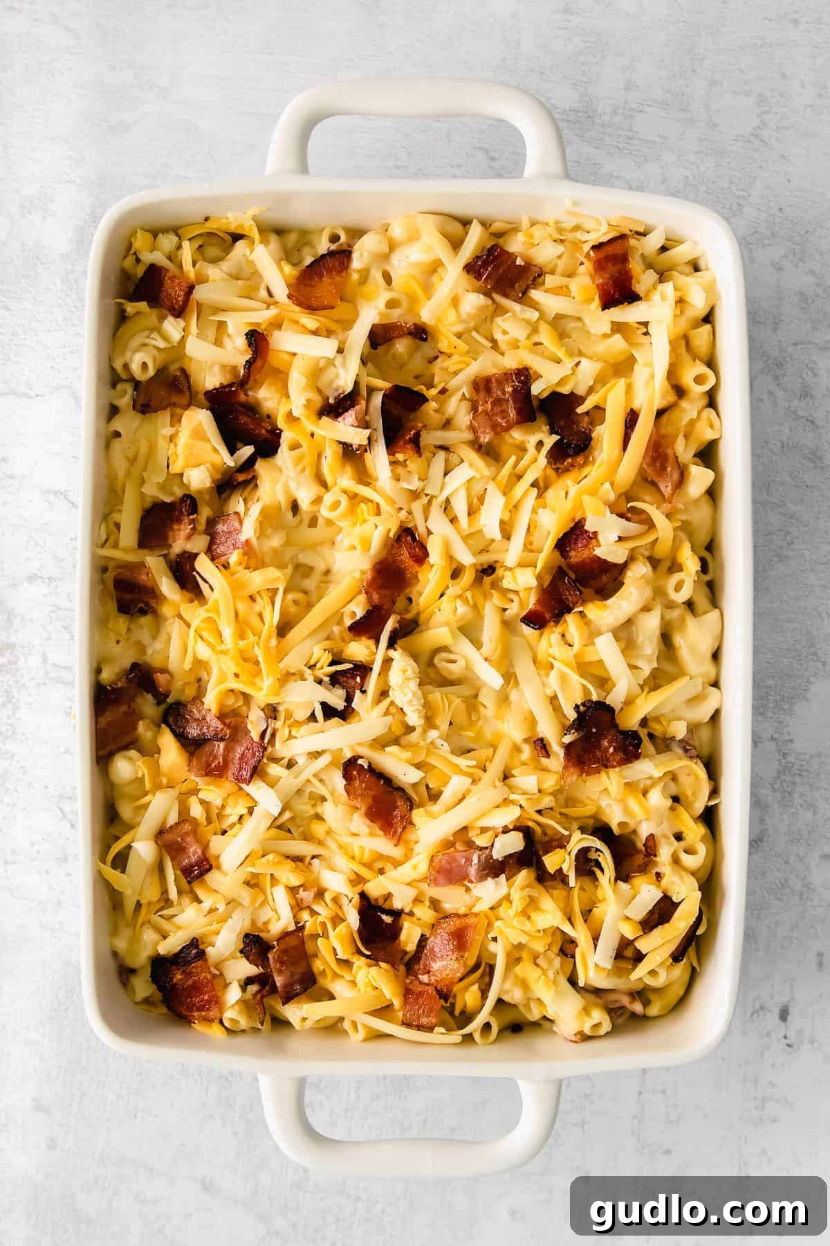 Freshly baked bacon mac and cheese, still bubbling and golden-brown in a casserole dish, topped with melted cheese.