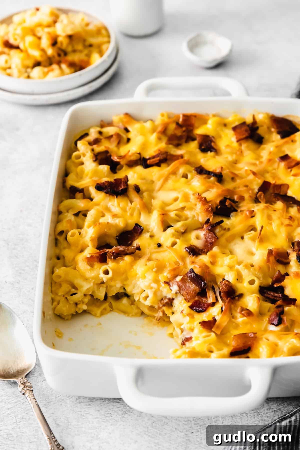 A close-up shot of baked mac and cheese in a casserole dish, showcasing its gooey cheese and golden crust.