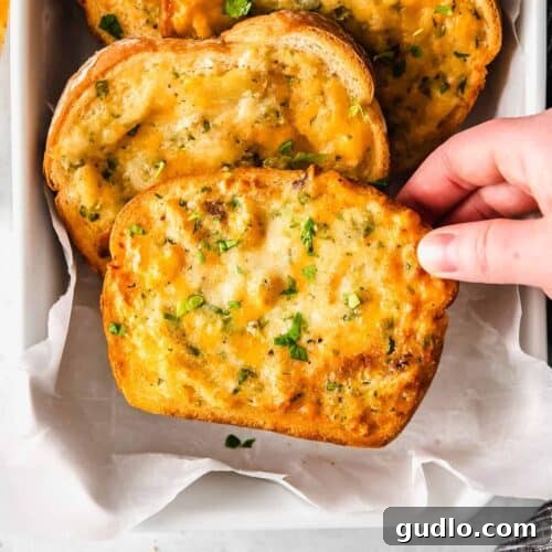A delicious slice of air fryer Texas toast with melted cheese and herbs, ready to be enjoyed.