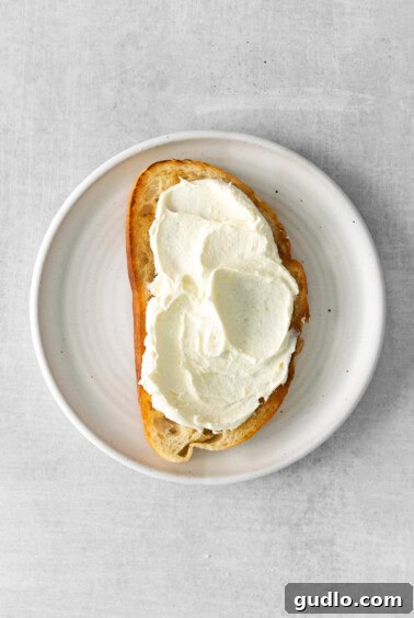 A slice of toasted bread with a generous spread of mascarpone cheese.