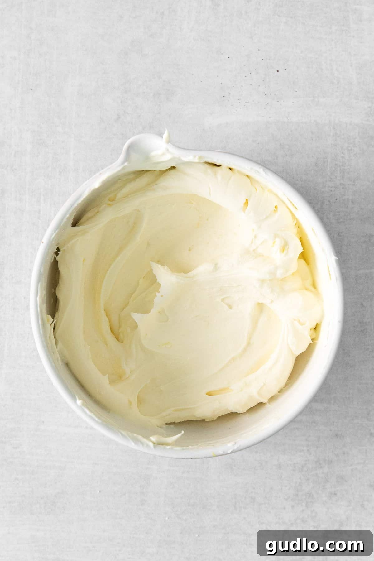 Creamy, white mascarpone cheese gently spread in a small, elegant bowl, highlighting its smooth and luxurious texture, ready to be prepared for delicious toast.