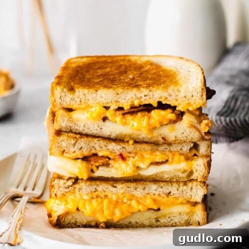 A stack of golden grilled cheese sandwiches, rich and inviting.