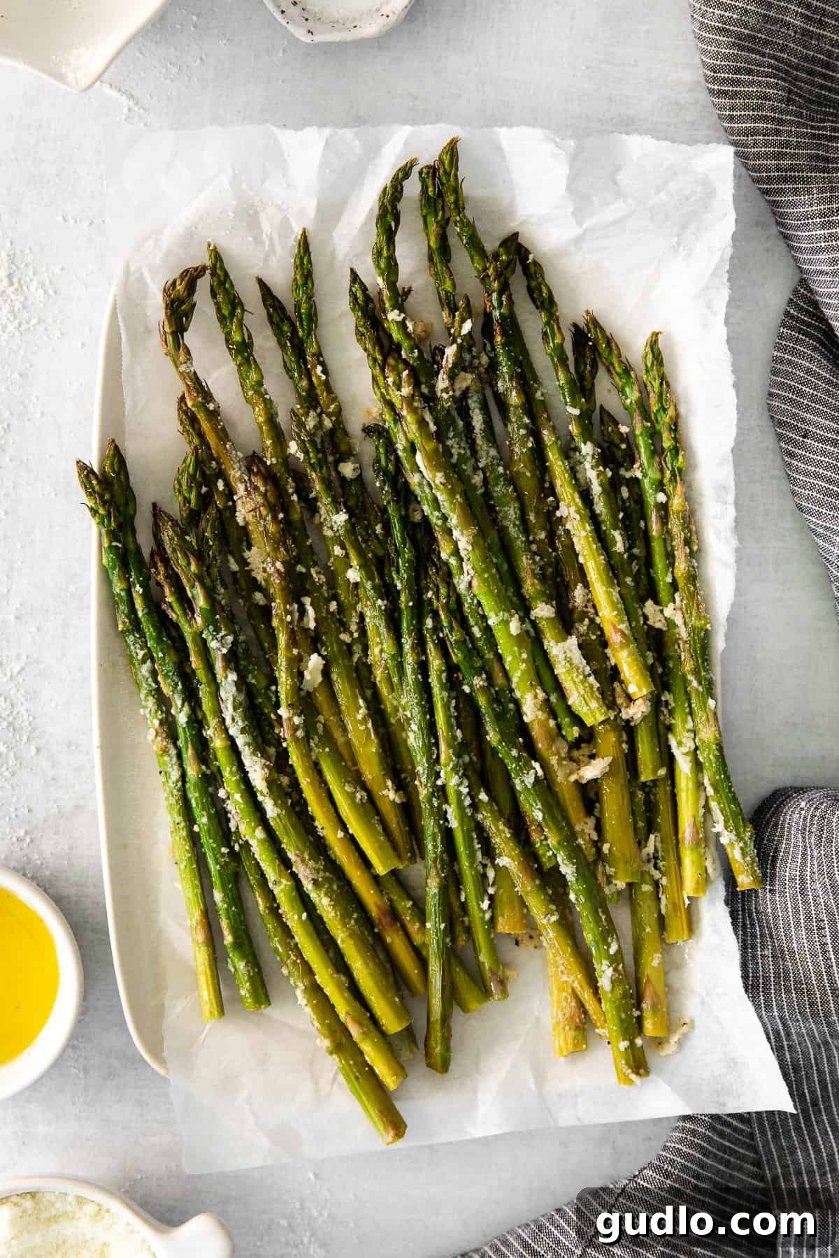 Super Easy Roasted Parmesan Asparagus: A Flavorful and Quick Side Dish for the Whole Family! A serving of perfectly roasted parmesan asparagus on a white plate, ready to be enjoyed.