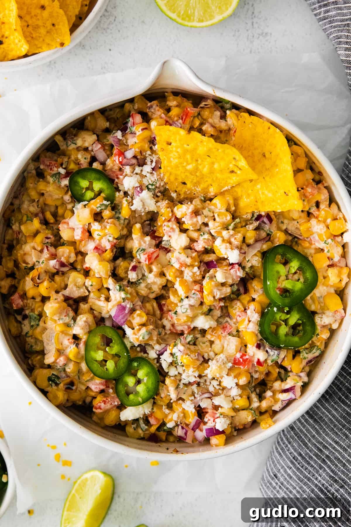 Vibrant Mexican corn salad generously topped with fresh jalapeños and cilantro, showcasing its rich colors and textures.