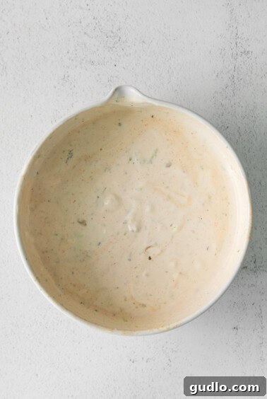 A white bowl with a creamy white sauce.