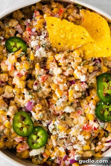 Finished Mexican corn salad in a white bowl, garnished with cilantro.