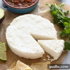 Freshly made queso fresco on parchment paper, ready to be crumbled.