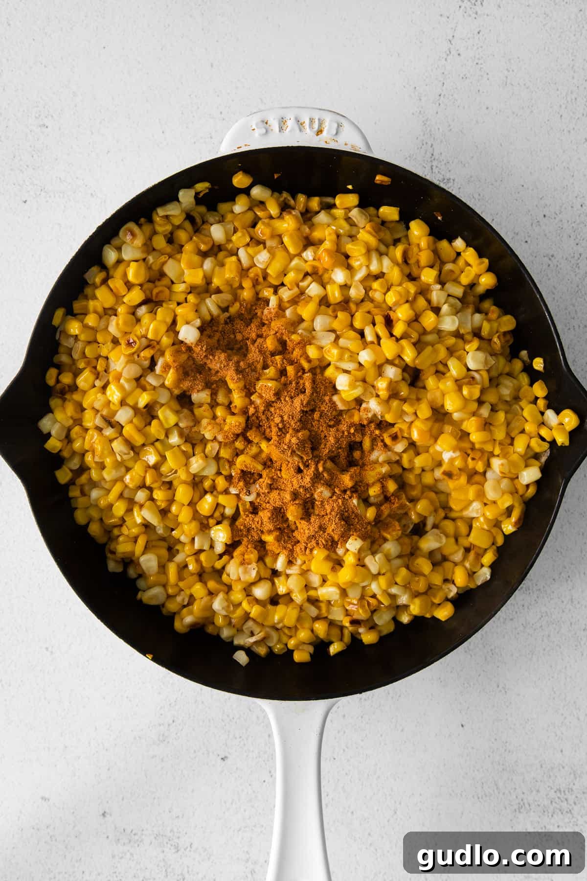 Sweet corn kernels browning and caramelizing beautifully in a hot cast iron skillet.