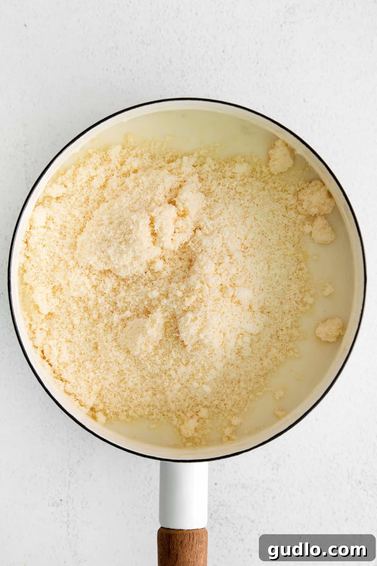 Creamy Garlic Parmesan Sauce 5 Freshly grated Parmesan cheese sprinkled generously on top of a serving of creamy garlic parmesan sauce.