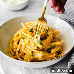 Creamy Garlic Parmesan Sauce 7 A fork spinning creamy garlic parmesan pasta, showcasing the rich sauce coating the noodles.