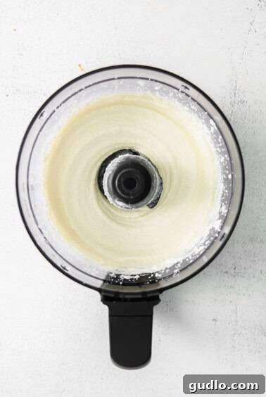 Creamy mixture of queso fresco, Greek yogurt, and lime juice in a food processor.