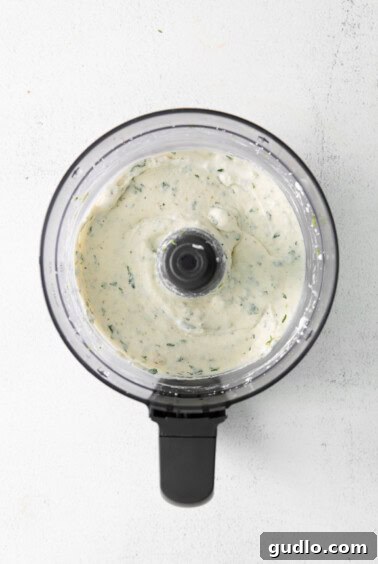The smooth, creamy queso fresco dip in the food processor bowl.