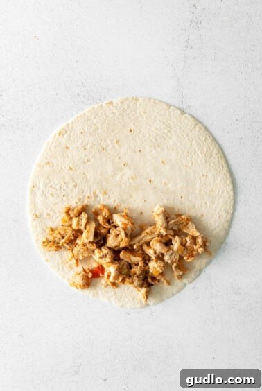 Quick and Crispy Air Fryer Quesadillas 5 A tortilla filled with chicken and cheese, folded over and secured with toothpicks.