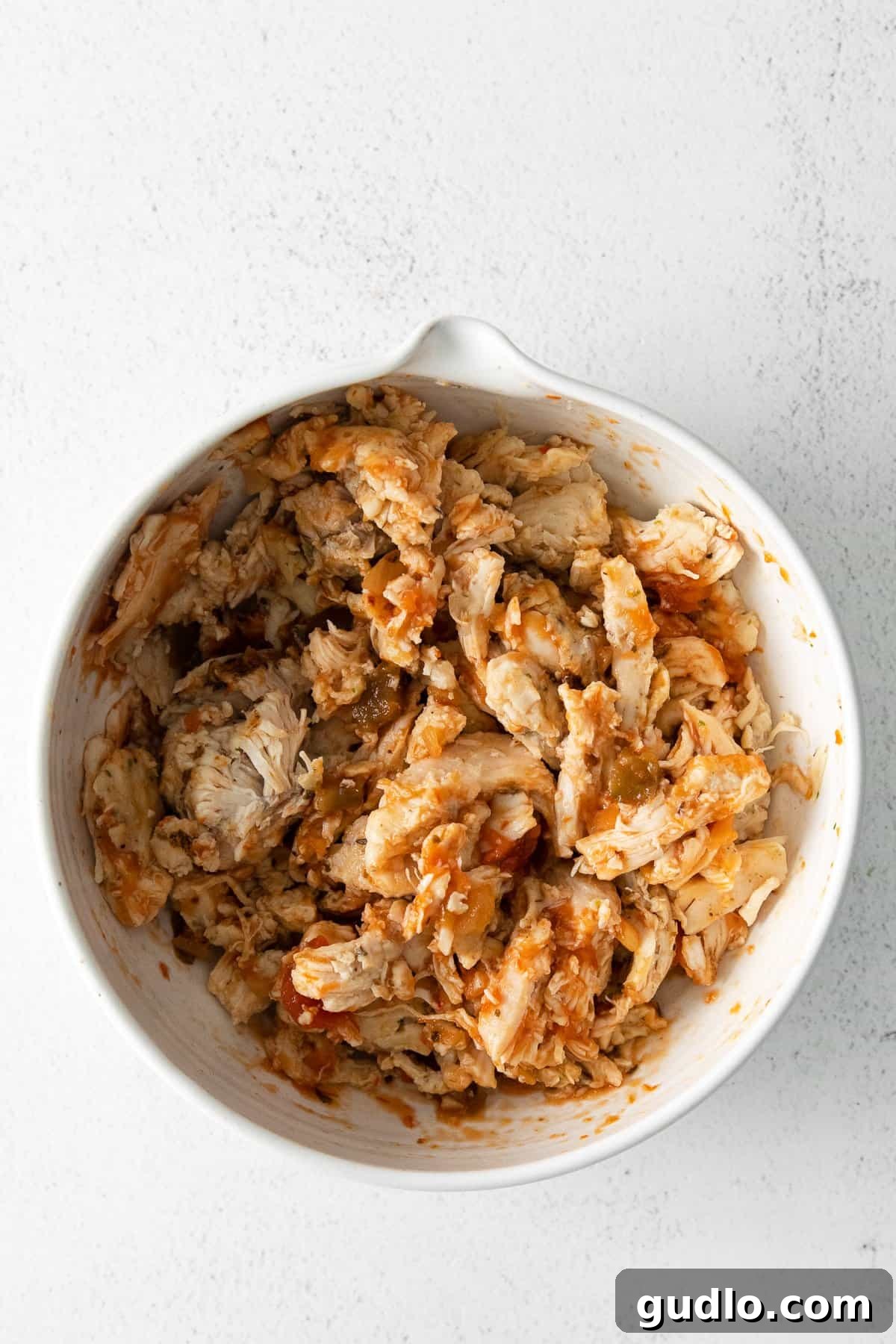 Flavorful Chicken and Salsa Mixture Shredded chicken mixed with salsa in a white bowl, ready for quesadilla assembly.